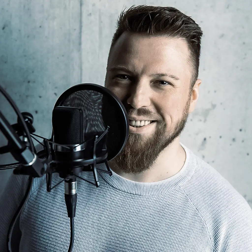 Pascal Krell lächelt hinter einem Studiomikrofon